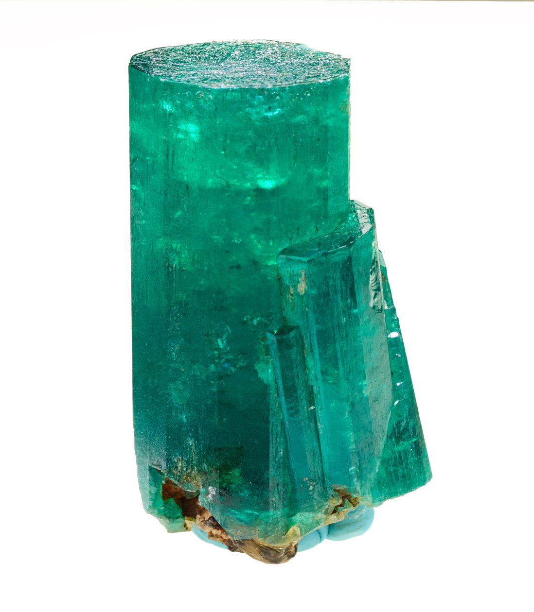 A large hunk of green emerald, unpolished, in the vague shape of a cylinder